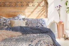 a carved wooden headboard adds a boho feel to the space and makes it look warm and welcoming