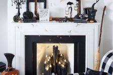 a glam Halloween mantel with black candles, a rhinestone pumpkin, a scary tree, banners, lights and a vintage clock
