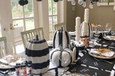 black and white striped pumpkins and candles make up stylish Halloween centerpieces for a modern party
