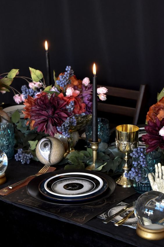 bright blooms greenery, black candles and large eyeballs for a unique Halloween party table