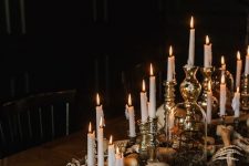 gorgeous Halloween table styling with moss, skulls, bones and lots of candles in metallic candleholders