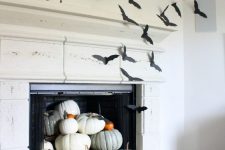 simple Halloween mantel decor with lots of bats and natural pumpkins on the fireplace cna be done last minute