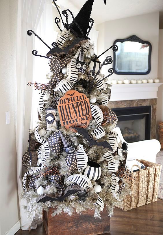 a grey Halloween tree with black and white garlands, signs, witch hats and bats is a bold idea
