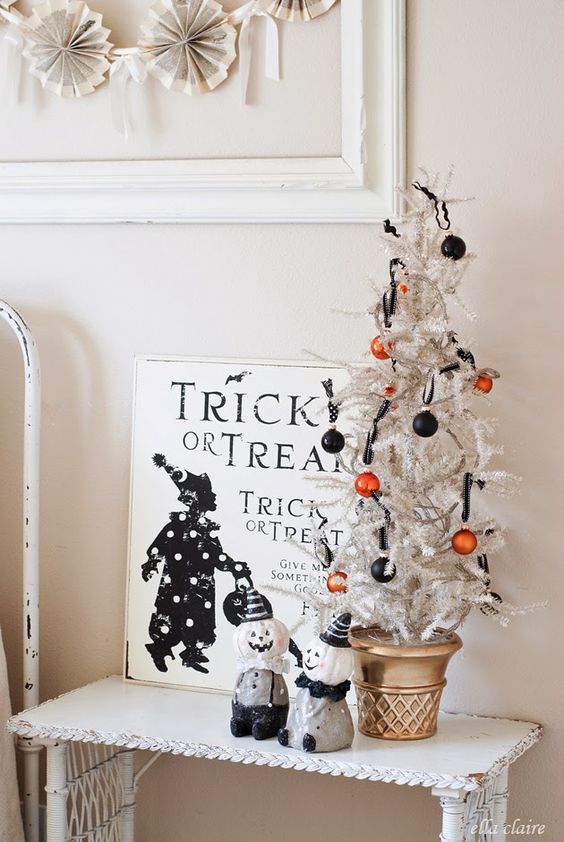 a mini white Halloween tree with orange and black ornaments is a cool and fast decoration for Halloween