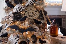 a vintage silver Halloween tree with bats, birds, skulls, garlands and lights is very exquisite