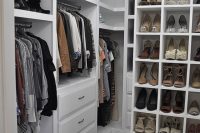 very well organized walk-in closet with white cabinets and storage units