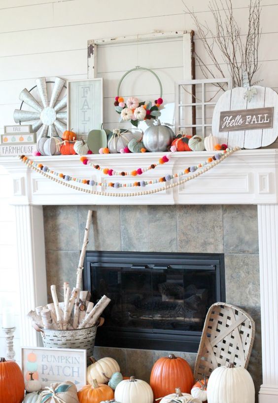 a bright fall or Thanksgiving mantel with colorful felt garlands, bright and metallic pumpkins, felt leaves and a sign