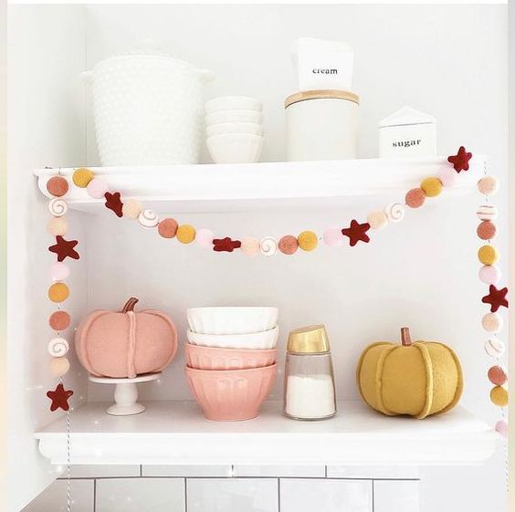 a bright felt Thanksgiving garland of stars, pumpkins and pompoms is a cool decoration you can buy or make