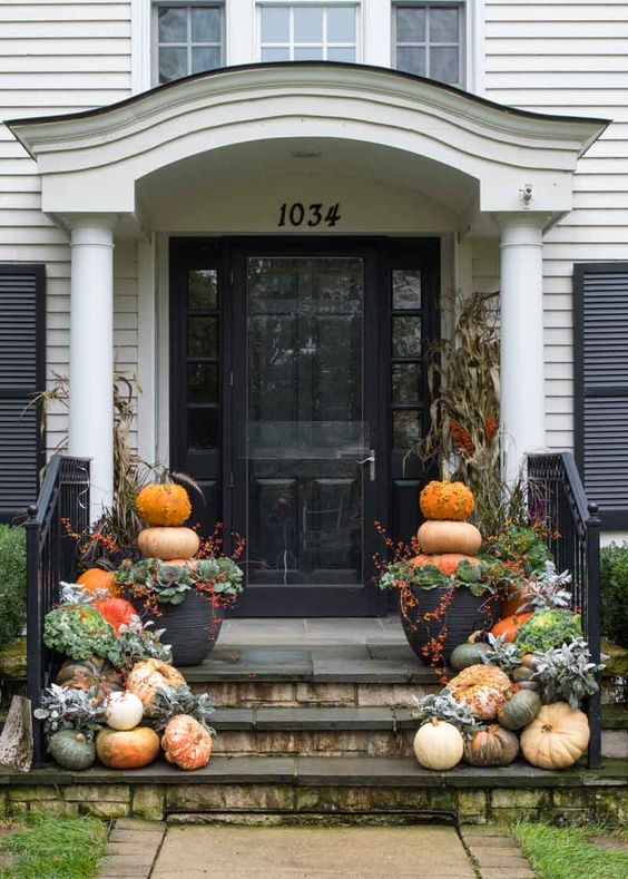 a cozy and easy fall porch with natural pumpkins, greenery and foliage, stacked pumpkins in pots is easy to recreate