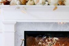 a gorgeous thanksgiving mantel with lots of fabric pumpkins with fabric leaves and a fabric pumpkin display next to the fireplace