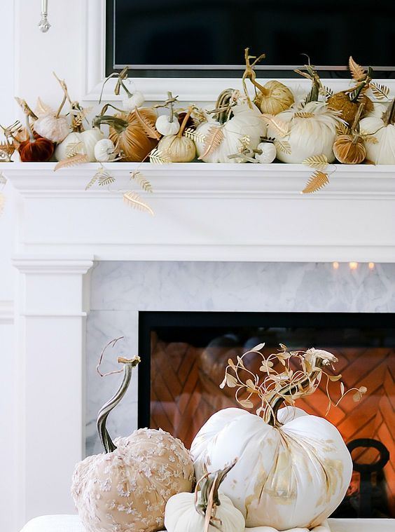 a gorgeous thanksgiving mantel with lots of fabric pumpkins with fabric leaves and a fabric pumpkin display next to the fireplace