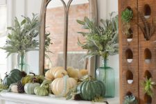 a rustic Thanksgiving mantel with various pumpkins, pinecones, greenery in bottles and leaves