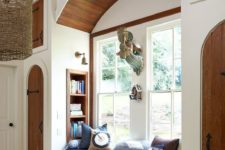 a traditional windowsill reading space with an upholstered bench with drawers and built-in stained bookshelves