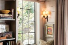 a vintage windowsill reading nook with a small upholstered bench, printed pillows and bookshelves next to it