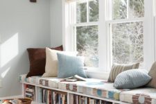 a windowsill bench with a cushion on top and a bookshelf inside it is perfect for a reading nook