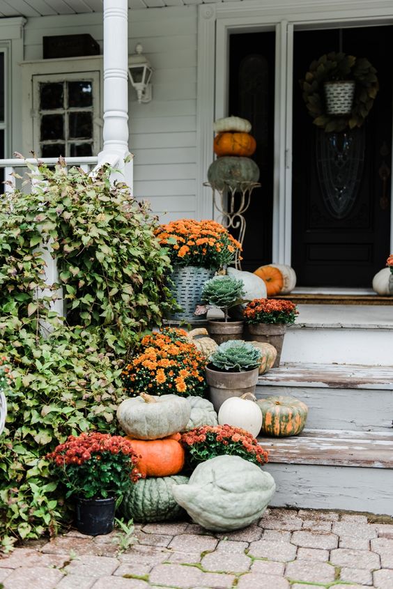 all-natural Thanksgiving porch decor with heirloom pumpkins, potted flowers and cabbages is very cute