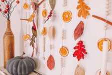 natural fall garlands with dried citrus slices, bright leaves, beads and cinnamon sticks are lovely for fall and Thanksgiving decor
