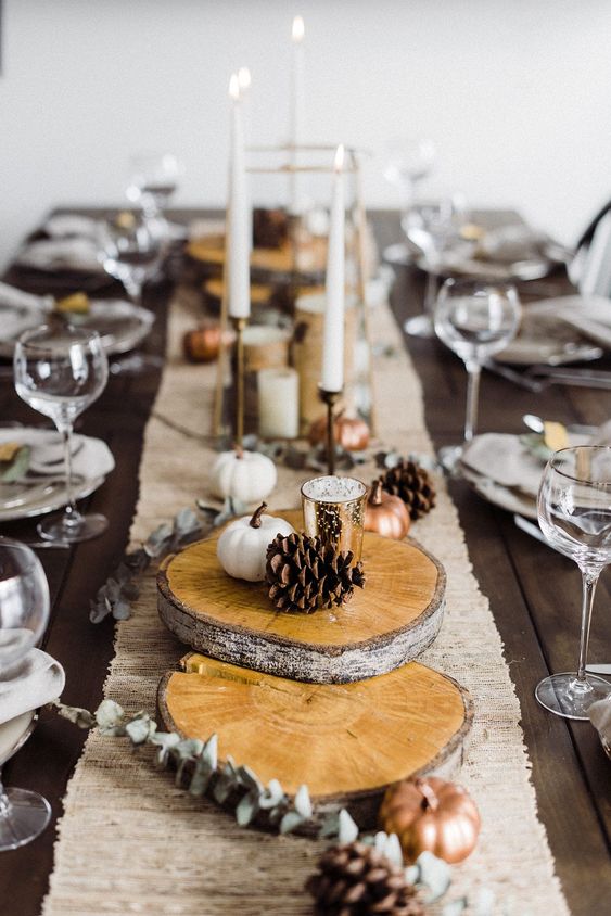 wood slices, dried eucalyptus, pinecones and mini white and copper pumpkins plus tall and thin candles are pure elegance