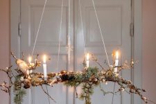 a branch chandelier with berries, candles and nothing else is a very natural decor idea