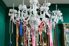 a crystal chandelier decorated with lots of colorful ornaments on colorful ribbon is a cool and catchy idea