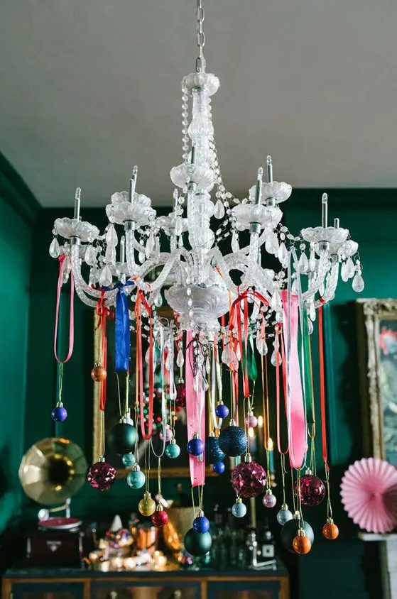 a crystal chandelier decorated with lots of colorful ornaments on colorful ribbon is a cool and catchy idea