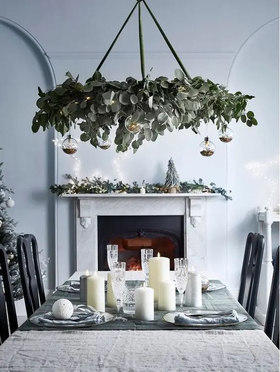 a modern holiday chandelier of eucalyptus, clear baubles with glitter inside is a stylsih modern Christmas decor idea
