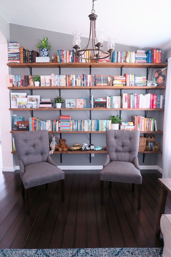 a reading nook with open shelves and a couple of comfy chairs is a cool idea for a farmhouse space like this one