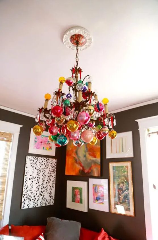 a regular chandelier completely covered with colorful ornaments is a stylsih and catchy idea for the holidays