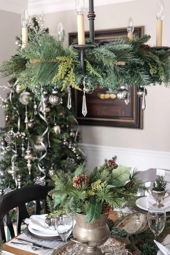 A vintage inspired Christmas chandelier with evergreens, silver ornaments and crystals is a stylish and cool idea to rock