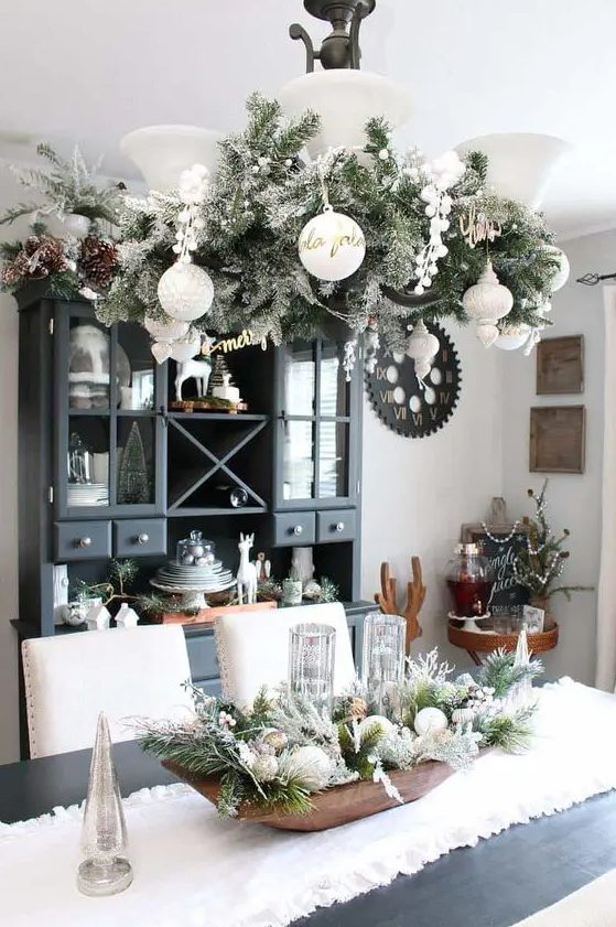 A vintage inspried chandelier with flocked evergreens, pinecones and white ornaments is a stylish farmhouse Christmas decor idea