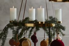 an elegant chandelier with pillar candles, gold, red and pink mismatching ornaments for Christmas
