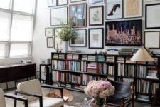 dark bookshelves and matchign dark furniture make the space stand out, and a gallery walls adds to the decor