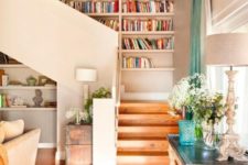 shelves built into the wall next to the staircase allow you saving space and look nice, plus stairs make it easy to reach them