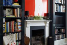 tall dark bookcases separated with a fireplace and a chair make up a nice mini library