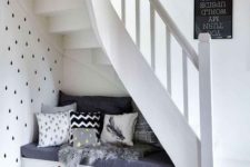a storage bench with pillows and faux fur will form a cozy little under the stairs sitting nook
