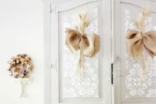 a dove grey wardrobe with white paint stenciling and burlap bows for a cozy rustic feel