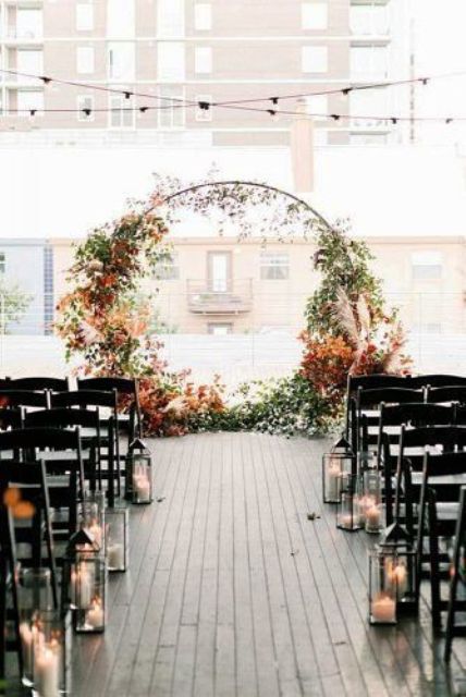 a round fall wedding arch decortaed with greenery, dried leaves and pampas grass is very chic