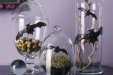 Halloween decor in jars and cloches, with hay, bats, branches and faux eggs is very chic and creative