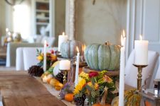 a bright fall tablescape with a burlap runner, bright blooms, natural pumpkins, pinecones and candles is very bold