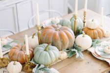a cozy and easy neutral fall tablescape with a macrame runner, candles, natural pumpkins, striped napkins and pale foliage