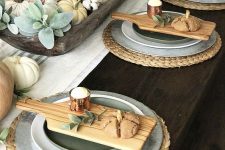 a cozy fall table setting with woven placemats, boards with food, pale greenery, cotton and natural napkins