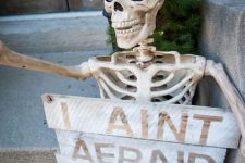 a skeleton with a sign is a nice decoration for your porch, backyard or just indoors, make one easily