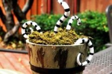 a wooden bucket with moss and black and white snakes from Nightmare Before Christmas
