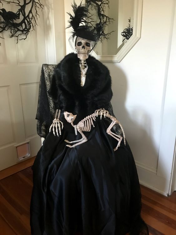 an elegantly dressed skeleton with a skeleton cat is a fantastic decoration for indoors, make one fore sure