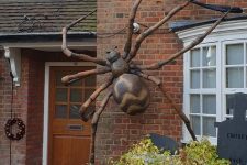 an oversized spider attached to a wall of your house is a lovely and spooky Halloween decoration