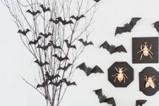 black paper bats attached to the wall and to the branches make the space look stylish and Halloween-like