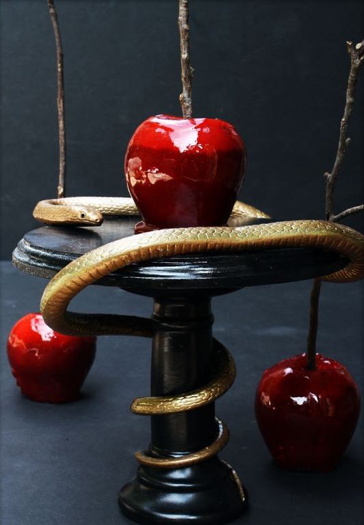 candied apples served on a stand and accented with a gold snake for Halloween