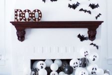 paper bats over the mantel, marquee letters and black and white balloons in the fireplace