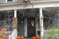 spiderwebs wtih large spiders and carved pumpkins create a stunning Halloween look for the front porch