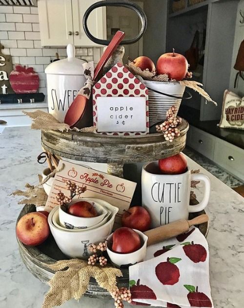 a cool fall decoration of a wooden stand with burlap leaves, red apples, printed fabrics, berries and wooden items